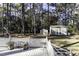 A charming backyard featuring a wooden deck and two storage sheds, surrounded by mature trees at 3540 Chelsea Dr, Rocky Mount, NC 27803