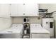 Functional laundry room with shelving, storage cabinets, a washer, a dryer, and a water heater at 3540 Chelsea Dr, Rocky Mount, NC 27803