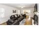 Open living room with a dark sofa set, light hardwood flooring, and an open view to the kitchen at 3540 Chelsea Dr, Rocky Mount, NC 27803