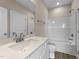 Bathroom with white vanity, quartz countertop and tub with white shower surround at 9133 Phoenix Ct, Middlesex, NC 27557