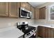 Close up of oven and microwave with white countertops and wood cabinets at 9133 Phoenix Ct, Middlesex, NC 27557
