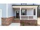 Close up of front door and porch with brick foundation and white railings at 9133 Phoenix Ct, Middlesex, NC 27557