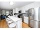 Modern kitchen features stainless steel appliances, white cabinets, and a breakfast bar that opens into the living area at 1320 S State Street # D, Raleigh, NC 27610