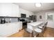 Modern kitchen with stainless steel appliances, white cabinets, and breakfast bar seating at 1320 S State Street # D, Raleigh, NC 27610