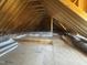 An unfinished attic space with exposed wooden beams, insulation and plywood flooring, ready to be transformed at 142 Batten Hill Ln, Selma, NC 27576
