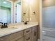 Bright bathroom with dual vanity, marble countertops, and tiled bathtub at 142 Batten Hill Ln, Selma, NC 27576