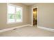 Bedroom with plush carpet, natural light, and a door leading to the bathroom at 142 Batten Hill Ln, Selma, NC 27576