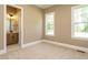 Bedroom with plush carpet, two windows, and adjacent bathroom at 142 Batten Hill Ln, Selma, NC 27576