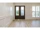 Elegant entryway with beautiful double doors, white trim and wood flooring at 142 Batten Hill Ln, Selma, NC 27576