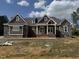 Stunning single-Gathering home featuring a stone and wood facade and a charming covered front porch at 142 Batten Hill Ln, Selma, NC 27576