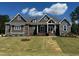 Beautiful single-story home boasting stone and brown plank siding with a well-manicured front lawn at 142 Batten Hill Ln, Selma, NC 27576