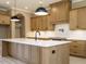 Island in kitchen features stone countertops, wooden cabinets, and modern light fixtures at 142 Batten Hill Ln, Selma, NC 27576