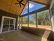 The sunroom features large picture windows offering scenic backyard views and a ceiling fan for comfort at 142 Batten Hill Ln, Selma, NC 27576