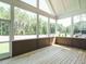 Screened-in sunroom with wood flooring and large windows overlooking a scenic backyard at 142 Batten Hill Ln, Selma, NC 27576