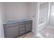 A new bathroom with gray cabinets and a white bathtub and shower combination at 1901 Old Bramble Ln # 3, Fuquay Varina, NC 27526