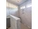 Elegant bathroom featuring marble tile walls, shower niche, and natural lighting from two windows at 1901 Old Bramble Ln # 3, Fuquay Varina, NC 27526