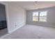 Bright bedroom featuring large windows with neighborhood views and neutral gray walls at 1901 Old Bramble Ln # 3, Fuquay Varina, NC 27526