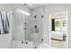 Modern glass enclosed shower with gray subway tile and a view into the main bedroom at 2330 Del Webb Gardens Dr, Fuquay Varina, NC 27526
