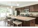 Modern kitchen with a large island, granite countertops, stainless steel appliances, and dark cabinets at 50 Calabria Ct, Franklinton, NC 27525