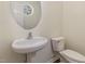 Compact powder room with a pedestal sink, modern faucet, and a toilet, offering essential convenience at 526 Elm Ave, Wake Forest, NC 27587