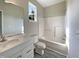 Bright bathroom with a single vanity, a toilet, and a tub/shower combo surrounded by white tile at 6 Heatherford Ct, Durham, NC 27704
