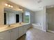 Bathroom with tile floors, double vanity, a large mirror, and a tub shower with glass doors at 6 Heatherford Ct, Durham, NC 27704