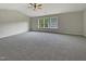 Large carpeted bedroom with neutral walls, vaulted ceiling, a ceiling fan, and natural light from the windows at 6 Heatherford Ct, Durham, NC 27704