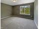 Bedroom showcasing neutral carpet, gray walls, and a window with a view of the neighborhood at 6 Heatherford Ct, Durham, NC 27704