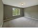 This gray bedroom has a single window that lets in plenty of natural light, complemented by neutral carpeting at 6 Heatherford Ct, Durham, NC 27704