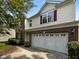 Two-story home featuring a brick and vinyl exterior, a garage, and a well-maintained lawn at 6 Heatherford Ct, Durham, NC 27704