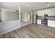 Open concept kitchen with white cabinets, modern appliances, and wood-style flooring at 6 Heatherford Ct, Durham, NC 27704