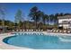 Community pool with ample seating and umbrella-shaded lounge area on a sunny day at 1833 Hydrangea Way, Fuquay Varina, NC 27526