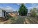Backyard featuring a brick home, brick raised garden beds, and mature landscaping at 2434 Orice St, Burlington, NC 27215