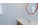 Well-lit bathroom featuring a single sink vanity with a circular mirror at 2434 Orice St, Burlington, NC 27215