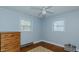 A cozy bedroom with a wooden dresser, hardwood floors, and natural light from two windows at 2434 Orice St, Burlington, NC 27215