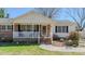 Close-up of the home's charming front porch with rocking chairs and brick steps at 2434 Orice St, Burlington, NC 27215