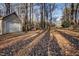 Beige detached garage with single door and leaf covered ground at 4027 Green Forest Ct, Rocky Mount, NC 27804