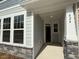 Inviting entryway with a covered porch and stone veneer on the support columns of the townhome at 424 La Maison Ave # 9, Wendell, NC 27591