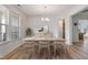 Bright dining room featuring a table set for four, wood floors, and a large window for natural light at 46 Two Belles Ct, Angier, NC 27501