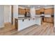 Well-lit kitchen features wood cabinets, stainless steel appliances, granite countertops and an island with seating at 46 Two Belles Ct, Angier, NC 27501