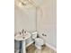 This bathroom features a pedestal sink, toilet, and modern lighting at 2625 Silver Gate Ct, Wake Forest, NC 27587