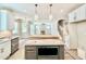View of the kitchen island and stainless steel appliances leading into the living room with a fireplace at 2625 Silver Gate Ct, Wake Forest, NC 27587