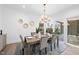 Bright dining room with wood table, velvet chairs, modern chandelier, and access to patio at 3410 Bradley Pl, Raleigh, NC 27607