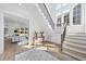 Bright foyer with hardwood floors, staircase, white walls, and an area rug near an open doorway at 3410 Bradley Pl, Raleigh, NC 27607