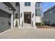 Elegant entryway with a wood front door, stone steps, black railings, and a paved driveway at 3410 Bradley Pl, Raleigh, NC 27607