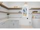 Bright laundry room features floating shelves, quartz countertop, undermount sink, and tiled flooring at 3410 Bradley Pl, Raleigh, NC 27607