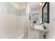 Clean bathroom with a tub and shower, a large mirror, pedestal sink, and tiled floor at 42 Oakwood Dr, Chapel Hill, NC 27517