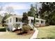 Charming white house with black shutters, landscaped front yard, and stone walkway leading to the front door at 42 Oakwood Dr, Chapel Hill, NC 27517