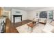 Cozy living room showcasing a decorative fireplace, hardwood floors, neutral furniture, and natural light at 42 Oakwood Dr, Chapel Hill, NC 27517