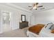 Serene bedroom featuring tray ceilings, ceiling fan, neutral tones and a glimpse into ensuite bathroom at 123 Wichita Way, Louisburg, NC 27549